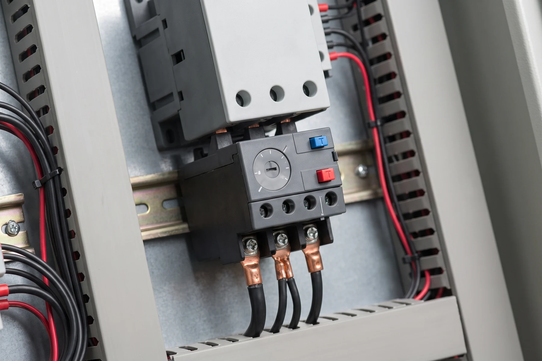 Thermal overload relay with current-setting dial mounted below a motor contactor in a control panel — Bombay Engineering Syndicate